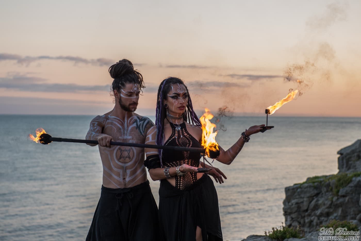 Duo choreographed fire show with two performers by the coast